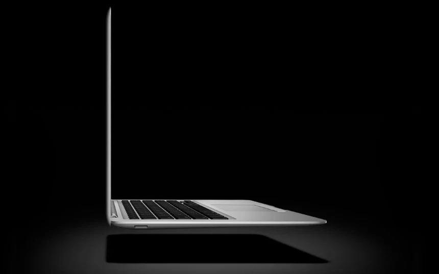Первый MacBook Air Early 2008 в профиль с открытым экраном на чёрном студийном фоне
